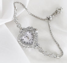 Load image into Gallery viewer, Heart-shaped rhinestone quartz watch with mother-of-pearl face, silver tone adjustable bracelet, vintage inspired design